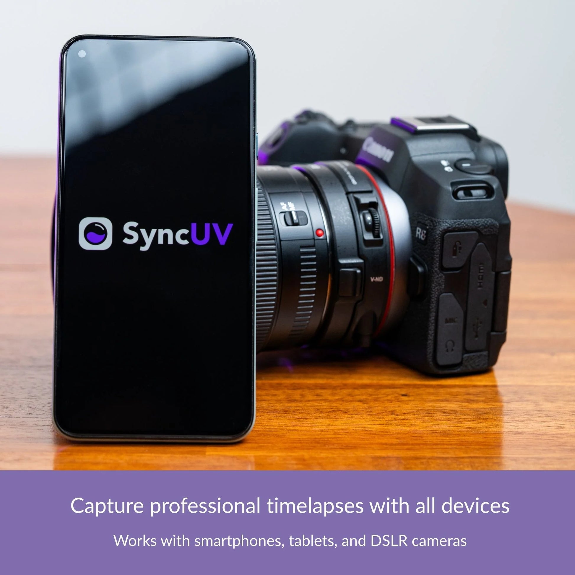 Smartphone next to a DSLR camera on a tabletop, showing SyncUV timelapse compatibility.
